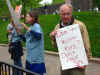Old man holding sign